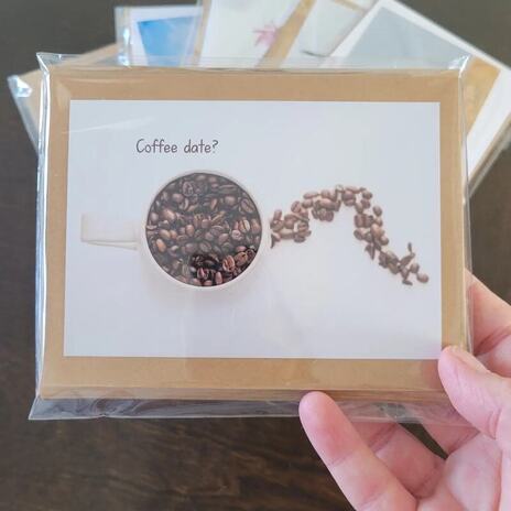 a greeting card with a coffee cup and coffee beans on the front