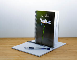 notebook with a daisy on the cover