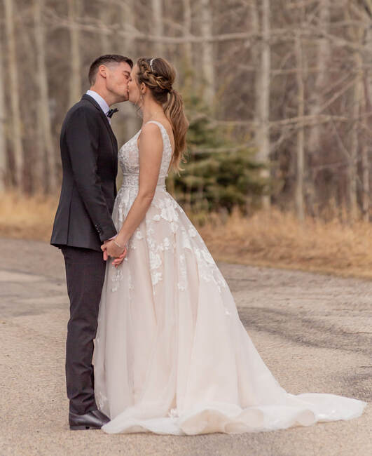 bride and groom kiss on a road
