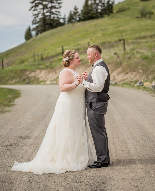 bride and groom hold hands on a gravel road