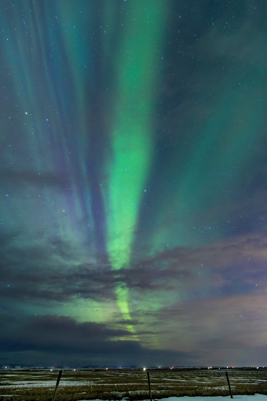 A large band of green Aurora stretches across the sky