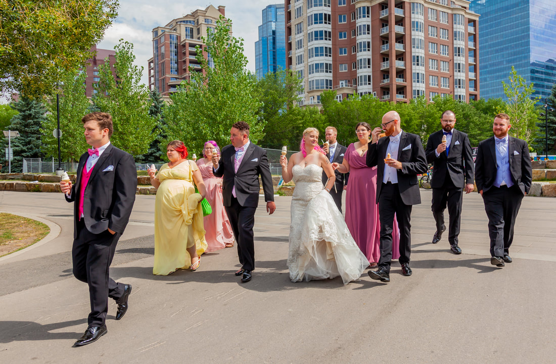 the bridal party walks through downtown while eating icecream