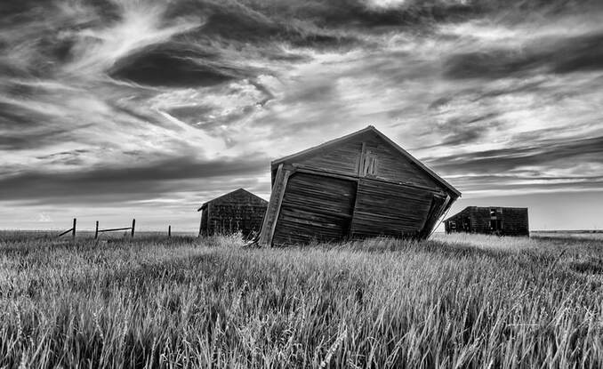 Leaning outbuildings during sunset (black and white)