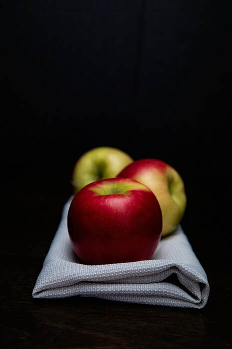 3 apples lay on a beige napkin